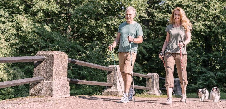elderly-couple-using-trekking-poles-long-shot-freepic-min